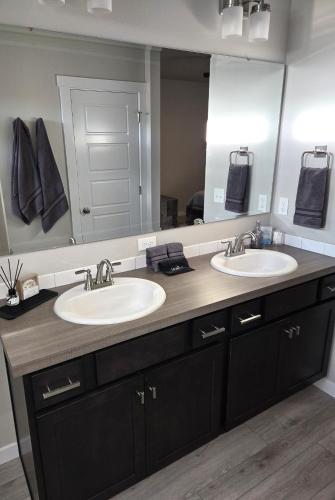 a bathroom with two sinks and a large mirror at StarLuxe Stay and Play in Star