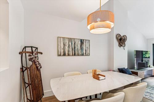 a dining room with a white table and chairs at Rivercourt Condo D2 in Stowe