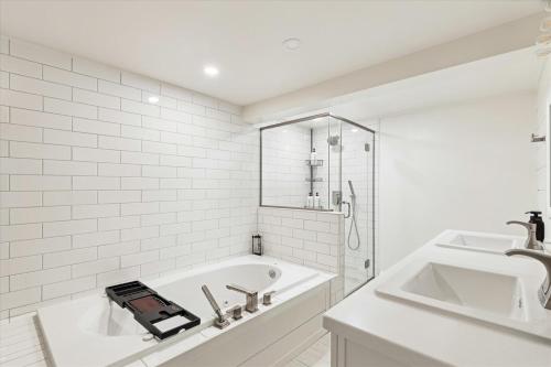 a white bathroom with a tub and two sinks at Maple Fox in Morrisville