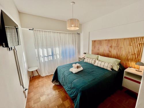 een slaapkamer met een bed met een knuffeldier erop bij Zelarrayan en el centro de Bahía - cochera y amenities in Bahía Blanca