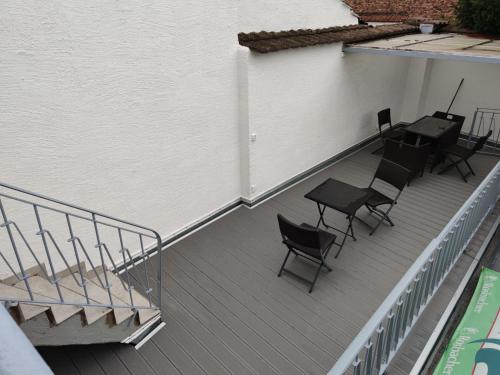 a balcony with chairs and tables on a building at Monteurzimmer Mühlheim am Main Nähe S-Bahn in Mühlheim