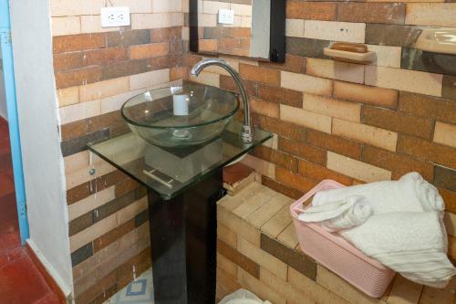 a bathroom with a glass bowl on a brick wall at Casa Santa Teresa de las Flores in Sogamoso