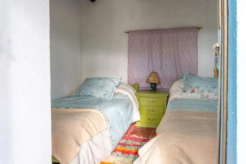 a bedroom with two beds and a mirror at Casa Santa Teresa de las Flores in Sogamoso