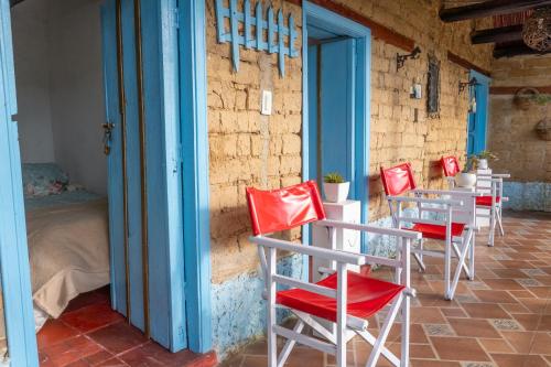 a row of red chairs and tables in a room at Casa Santa Teresa de las Flores in Sogamoso