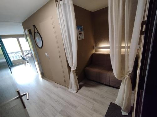 a hallway with curtains and a couch in a room at Studio Élégant Les Orres1650 in Les Orres