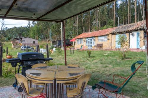 a patio with a table and a grill in a yard at Casa Santa Teresa de las Flores in Sogamoso