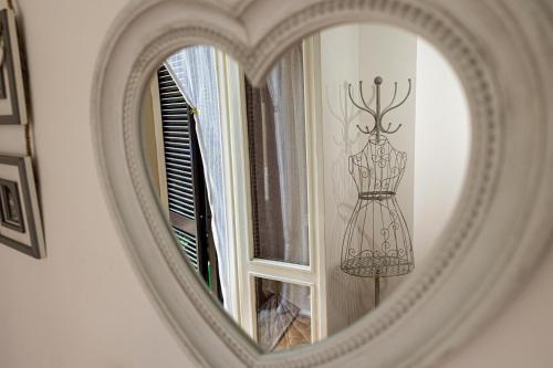 a mirror with a reflection of a dress on a window at La Casa di Brunina - Sentirsi a casa - Con garage auto in Monza