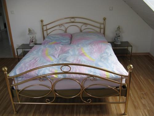 a bed with a metal frame with a colorful comforter at Ferienwohnung Am Kapellenäcker in Neumarkt in der Oberpfalz