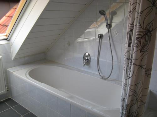 a bath tub in a bathroom with a shower at Ferienwohnung Am Kapellenäcker in Neumarkt in der Oberpfalz