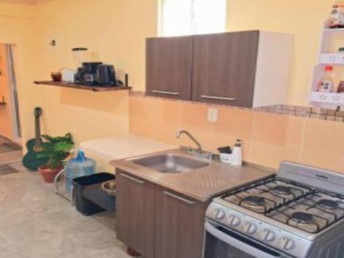 a kitchen with a sink and a stove top oven at Downtown Private Apartment Wkitchen Isla Mujeres in Isla Mujeres