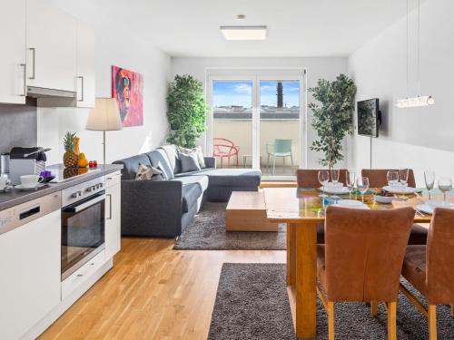 a kitchen and living room with a table and a couch at Modern City Apartment near Vienna Central Station in Vienna