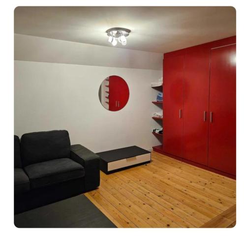 a living room with a black couch and red cabinets at Holzchalet mit Garten und Terrasse in Egnach