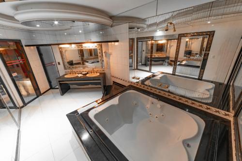 a large bathroom with a tub and a sink at Status Elegance Hotel in Serra
