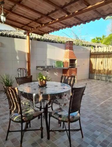 una mesa de cristal y sillas en un patio en Apartamento na Praia do Mutá, en Santa Cruz Cabrália