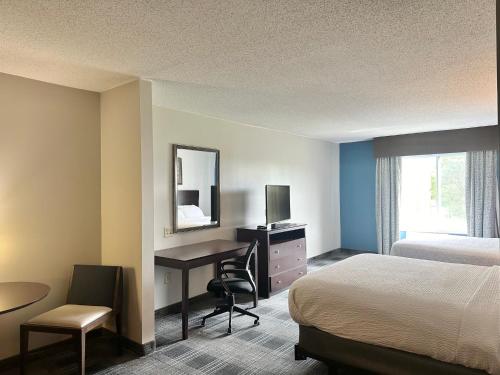 a hotel room with a bed and a desk with a computer at Holiday Inn Express and Suites Meriden by IHG in Meriden