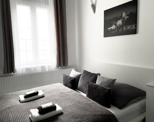 a bedroom with a bed with two towels on it at Belvárosi Apartman in Miskolc