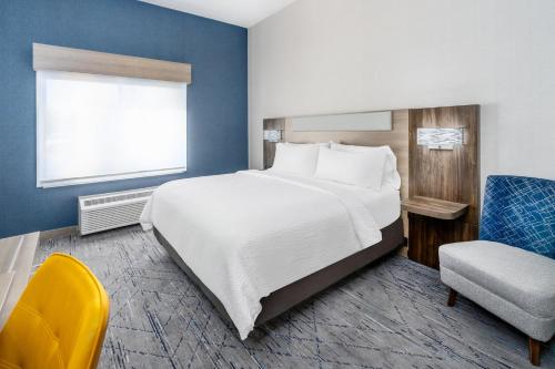 a hotel room with a large bed and a chair at Holiday Inn Express Casper I-25 by IHG in Casper