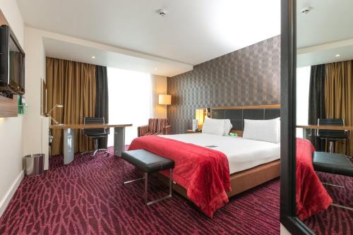 a hotel room with a large bed with a red blanket at Holiday Inn Manchester-Mediacityuk by IHG in Manchester