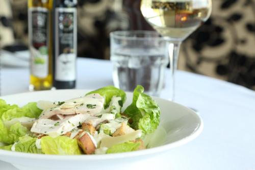 a white plate with a salad and a glass of wine at Holiday Inn Manchester-Mediacityuk by IHG in Manchester