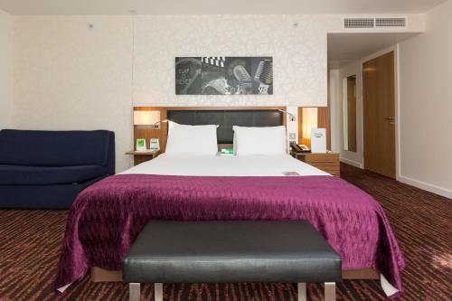 a hotel room with a bed and a blue chair at Holiday Inn Manchester-Mediacityuk by IHG in Manchester