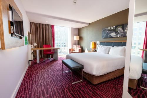 a hotel room with a large bed and a desk at Holiday Inn Manchester-Mediacityuk by IHG in Manchester