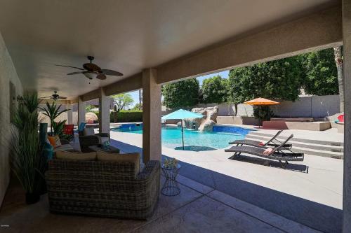a living room with a swimming pool and a patio at Spacious 5BR Retreat Pool Grill 15 Min to Westgate in Litchfield Park