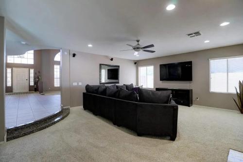 a living room with a couch and a flat screen tv at Spacious 5BR Retreat Pool Grill 15 Min to Westgate in Litchfield Park