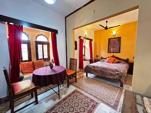 a bedroom with a bed and a table in a room at Killa Bhawan Lodge in Jaisalmer