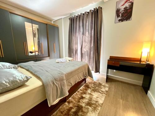 Un dormitorio con una cama y una cómoda y una ventana. en Apartamento Inteiro - 2 Quartos com AC - Wifi 1000mb - Cozinha Completa - 1 Vaga de Garagem - Elevador - Sacada Gourmet - Indicado para Grupos, Hospedes a Trabalho, Família e Pets, en Toledo