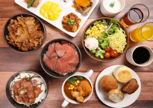 a table with many plates of food on it at APA Hotel TKP Sapporo Eki-Kitaguchi Excellent in Sapporo