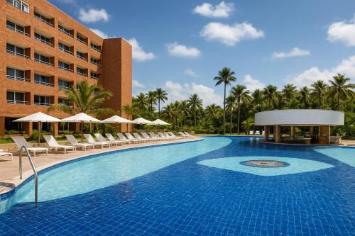 a large swimming pool with chairs and a hotel at FLAT EM BARREIRINHAS - Gran Solare Lencois in Barreirinhas