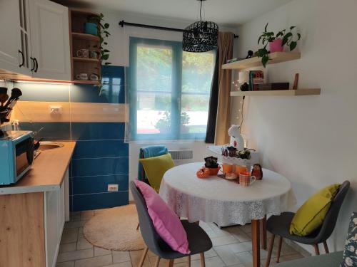 a small kitchen with a table and chairs in a room at Healing Garden Leányfalu in Leányfalu