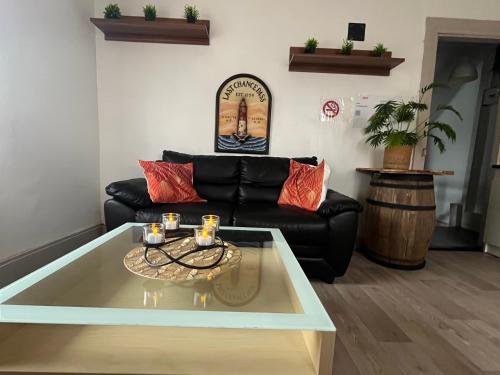 a living room with a black couch and a glass table at L'appart avec jardin in Malmerspach