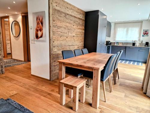 jadalnia z drewnianym stołem i krzesłami w obiekcie Cornelia 1 Ski-In-Out Stunning Views & Sleeps 8 w mieście Saas-Fee