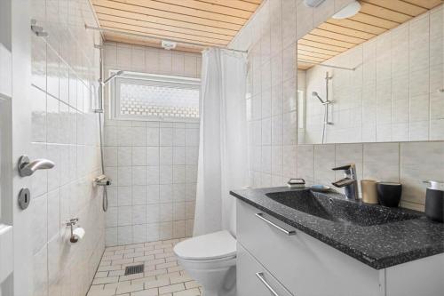 a bathroom with a sink and a toilet and a shower at 6836 Allinge - Fjeldvej 14 in Sandvig
