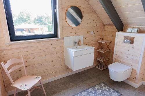 a bathroom with a toilet and a sink and a window at Podlaskie Chatki Ciszą Malowane - Domek nr 3 in Krynki