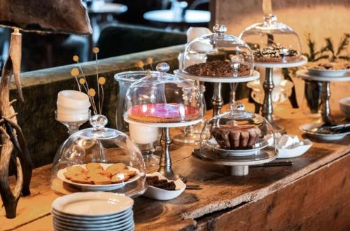 a table with plates and desserts in glass domes at Alpes Hôtel du Pralong in Courchevel