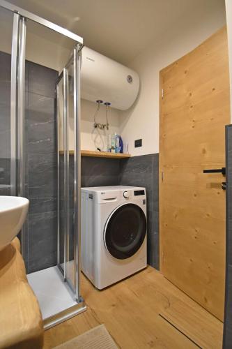 a washing machine in a bathroom next to a sink at Presanella View Studio Mhd in Madonna di Campiglio
