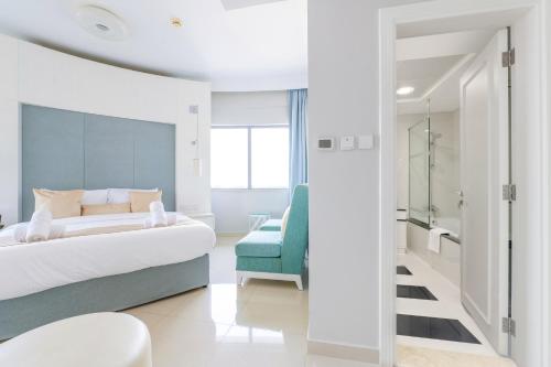 a bedroom with a bed and a blue chair at Damac Mall Street Residences in Dubai