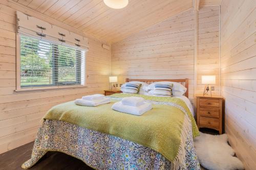 IngsにあるSpinney Lodge - High Borrans Farmのタオルが敷かれたベッドのある寝室