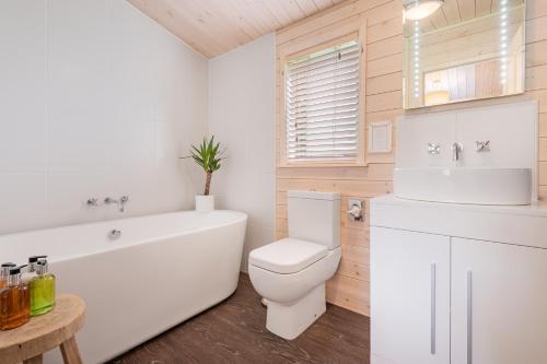 IngsにあるSpinney Lodge - High Borrans Farmのバスルーム(白いバスタブ、トイレ、シンク付)