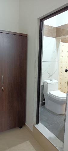 a bathroom with a toilet and a sliding glass door at River Soul Villa, Vagamon in Kattappana