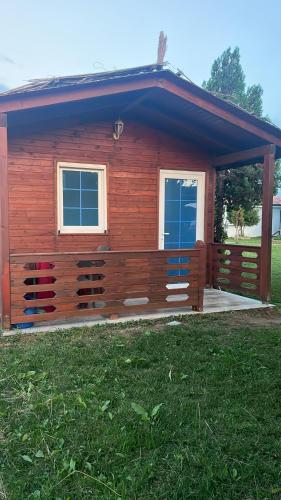 a log cabin with a porch and two windows at Shtepia Druri Sokol Lulaj in Lezhë