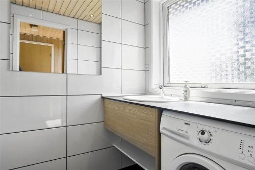 a white bathroom with a sink and a washing machine at 6682 Allinge - Brunekulvej 2 E in Allinge
