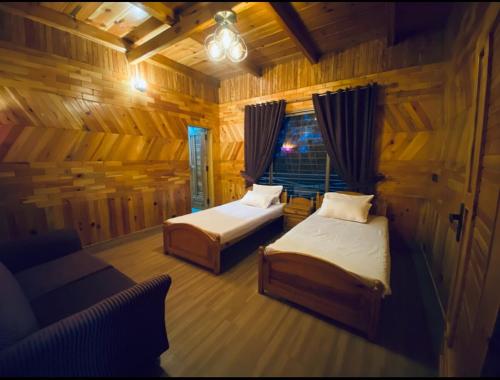 een slaapkamer met twee bedden en een bank en een raam bij 4BHK Dunga Gali in Dunga Gali