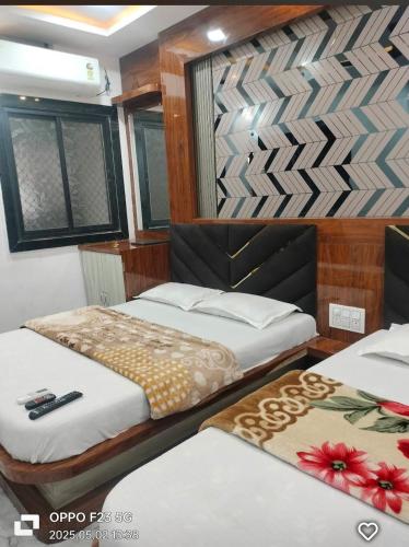 two beds in a small room with two at Hotel shree shivay omkareshwar in Godarpura