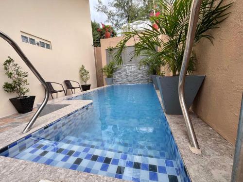 ein Schwimmbecken mit blauen Fliesen auf dem Boden und ein Gebäude in der Unterkunft Humble Cocoon1-2BR Unit House Near Inflatable Island & Subic Bay Yacht in Subic