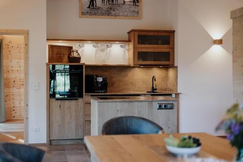 a kitchen with wooden cabinets and a table at Chalets am Duschl-Hof in Bayerbach
