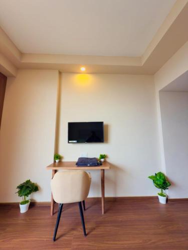 a desk with a chair and a television on a wall at Omaxe trade centre alpha 2 in Greater Noida