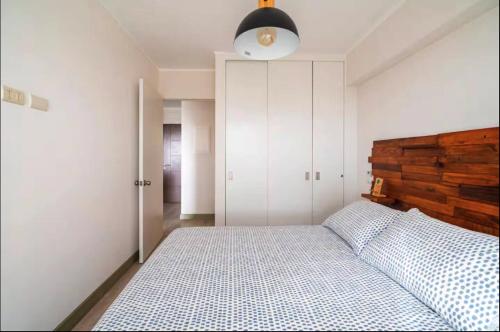 a bedroom with a bed with a wooden headboard at Connect Apartment by Vibrant in Lima